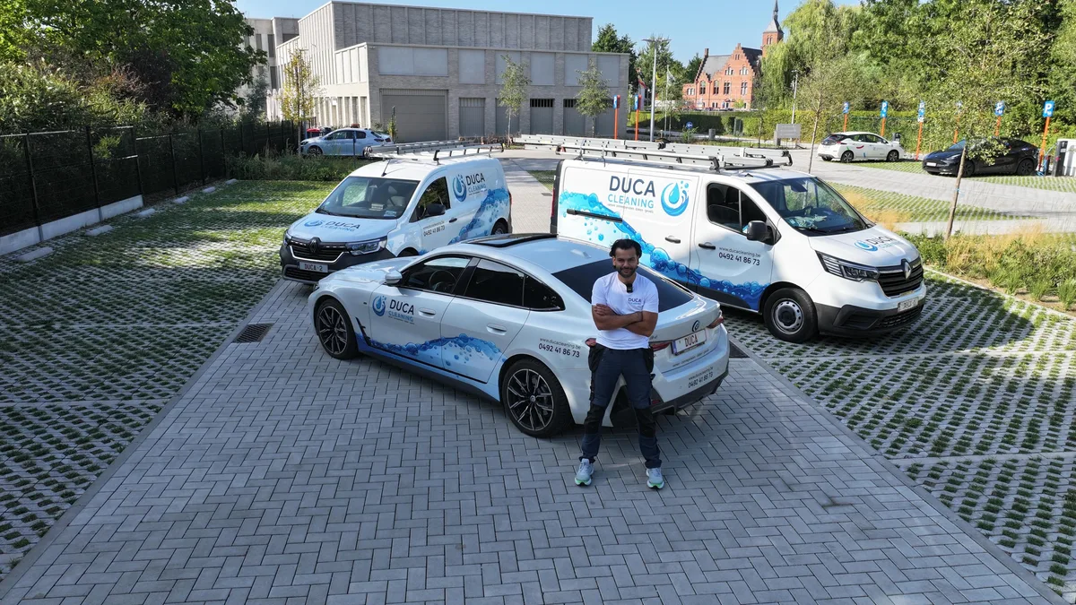 Duran, zaakvoerder van DUCA Cleaning, voor de drie bestickerde bedrijfswagens van het eigen team