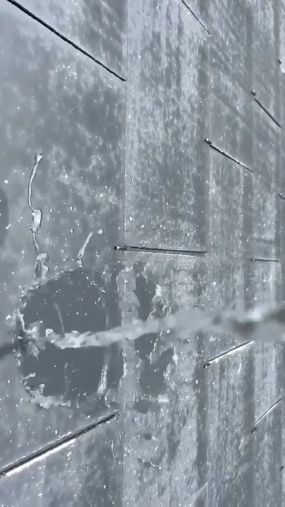 Water dat wegspat en afparelt op dakpannen met een verse dakcoating van DUCA Cleaning